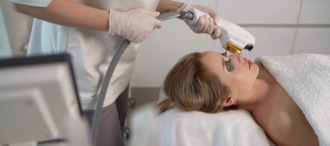 a woman wearing eye covers receives laser treatment to the face