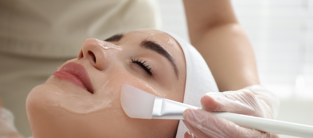 a treatment is applied to a woman's face with a soft brush