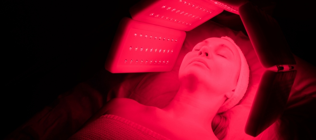 a woman's face surrounded by red light panels