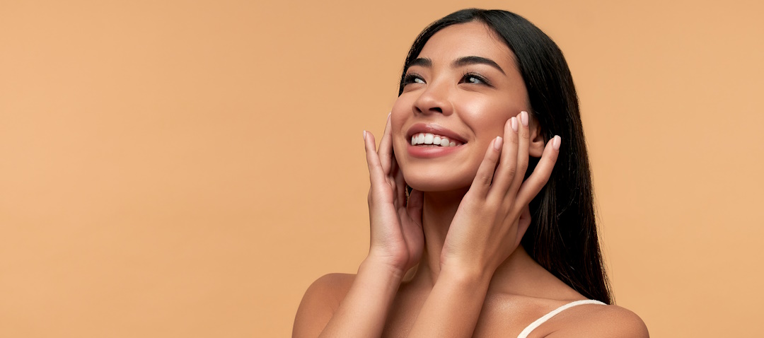 woman holding her face and smiling toward the side