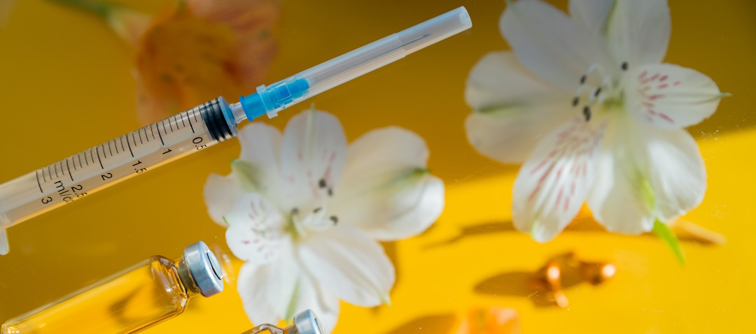 botox needle and vials with flowers in the background