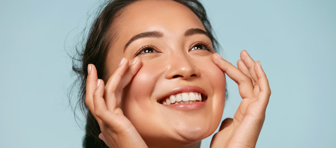 woman smiling with her hands on her face