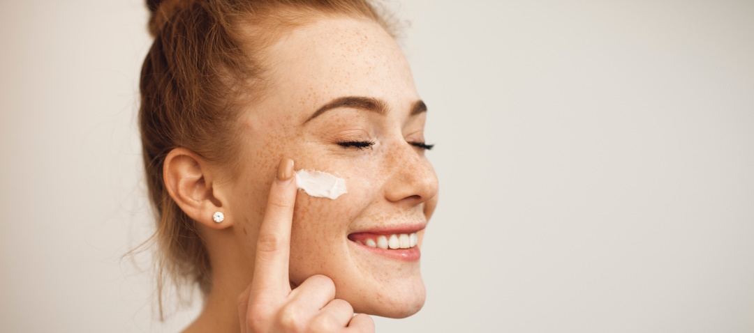 woman applying face moisturizer